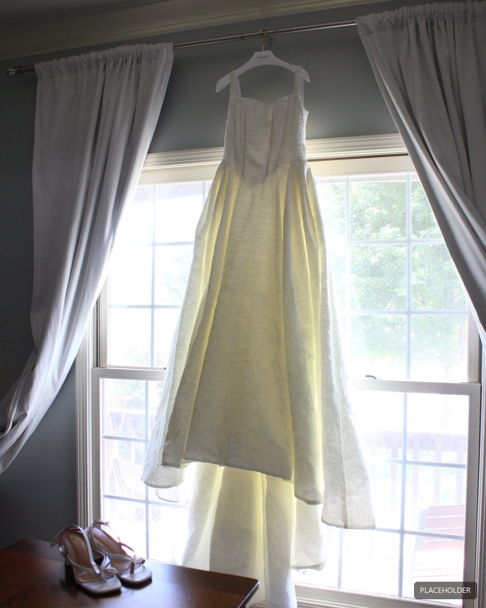 A wedding dress hanging in the window